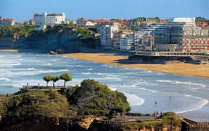 Un paysage urbain côtier avec une plage, des falaises et des bâtiments.