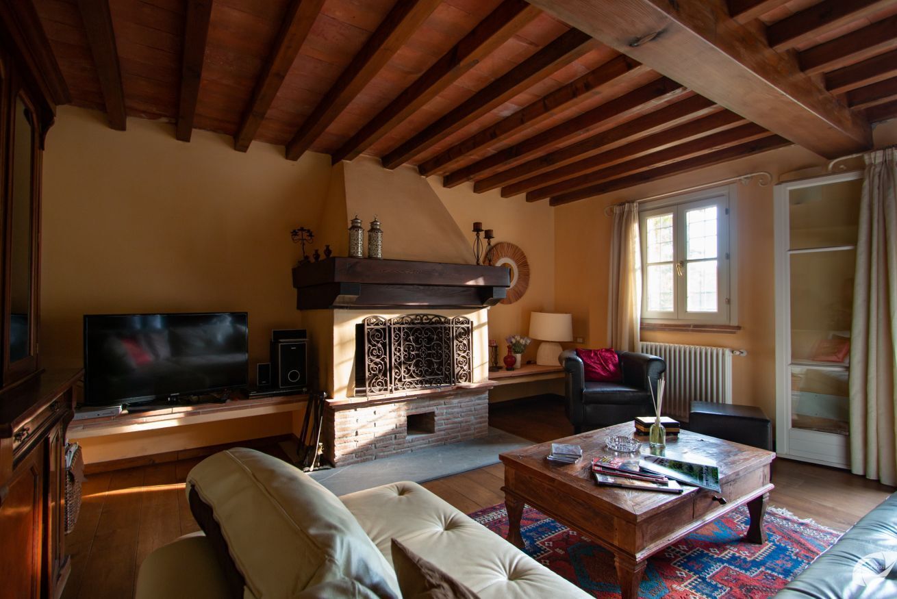 Ein Wohnzimmer mit Kamin, Fernseher, Sofa und Couchtisch.