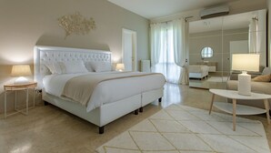 A modern hotel room with a large bed, a sitting area with a small table, and a large mirror. - Exclusive Villa with Spectacular Panoramic Views - Excellent location ★★★★★ (Pescara)