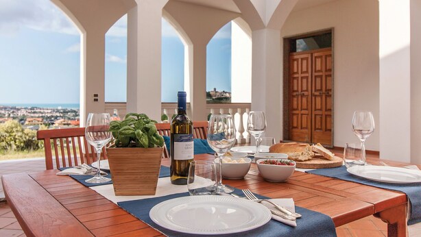 A dining table set with wine glasses, plates, and a bottle of Pinot Grigio, overlooking a scenic view. - Exclusive Villa with Spectacular Panoramic Views - Excellent location ★★★★★ (Pescara)