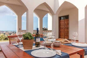A dining table set with wine glasses, plates, and a bottle of Pinot Grigio, overlooking a scenic view. - Exclusive Villa with Spectacular Panoramic Views - Excellent location ★★★★★ (Pescara)