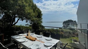 Ein Essbereich im Freien mit einem Tisch für vier Personen, mit Blick auf eine schöne Aussicht.