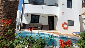 A modern two-story building with a pool in front, palm trees, and a clear blue sky. - Villa in Puerto del Carmen, Lanzarote, Canary Islands  (Tías)