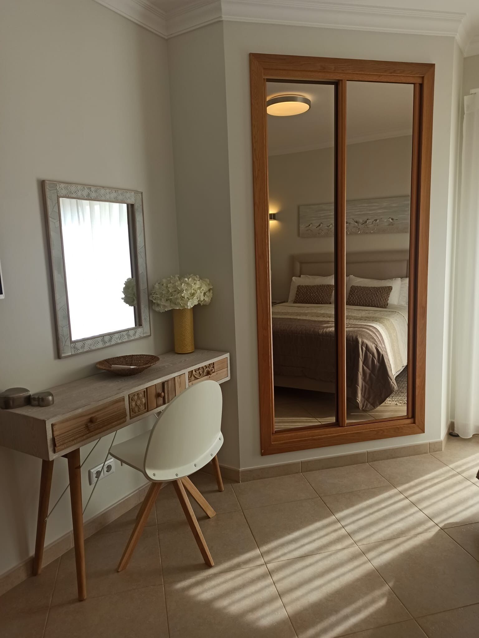 View of dresser and sliding wardrobes, safe, smart Tv and balcony