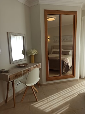 A bedroom with a wooden wardrobe, a desk with a chair, a large mirror, and a bed with a headboard. - 3 bedroomed villa with a south facing private garden access to golf and pool (Lagos)
