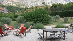 A patio with outdoor furniture, a table, and chairs, set against a backdrop of rocky mountains and greenery. - LA FEUILLERE, 17 CENTURY MANSION.  (Saint Antonin sur Bayon)