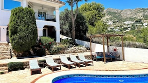 A pool area with lounge chairs, a pergola, and a view of a hillside. - La Jacaranda - Stunning Villa with Apartment in Mijas with panoramic sea views. (Mijas, Malaga)