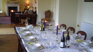 A dining room with a long table set for a meal, featuring white plates, glasses, and cutlery. - Family Friendly Spacious Home On Large Grounds With Panoramic Views (Aughrim)