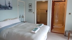 A hotel room with a bed, a shower, and a door leading to a bathroom. - Family Friendly Spacious Home On Large Grounds With Panoramic Views (Aughrim)