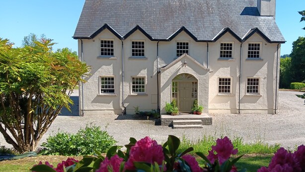 A two-story building with a symmetrical facade, a central entrance, and a gravel driveway. - Family Friendly Spacious Home On Large Grounds With Panoramic Views (Aughrim)
