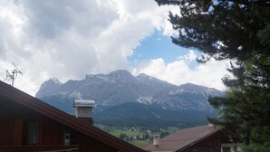 Vista de la montaña con una cabaña de madera y una casa en primer plano.