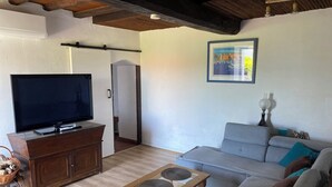 Sala de estar com televisão, sofá e mesa de centro.