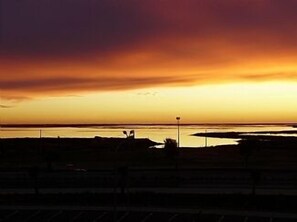 A sunset view from a beach with a fence in the foreground. - Five* Apartment with Beautiful Sea Views from the Balcony (Olhao)