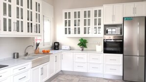 A modern kitchen with white cabinetry, a stainless steel refrigerator, a built-in oven, a coffee maker, and a toaster. - CHALET ON THE FIRST LINE OF THE SEA, 5 METERS !! FREE WIFI (El Mojón)