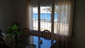 A dining table with chairs, a bowl of fruit, and a potted plant. - CHALET ON THE FIRST LINE OF THE SEA, 5 METERS !! FREE WIFI (El Mojón)