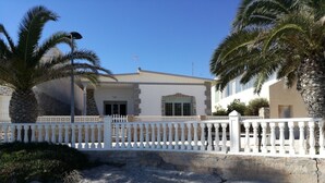 A white building with a balcony, palm trees, and a white fence. - CHALET ON THE FIRST LINE OF THE SEA, 5 METERS !! FREE WIFI (El Mojón)