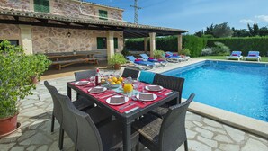 An outdoor dining area with a pool, stone walls, and lounge chairs. - VILLA MARIA - RUSTIC STAY (Pollensa)