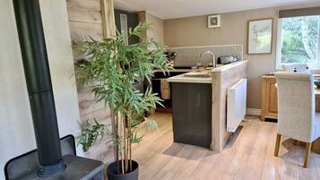 A modern kitchen with a built-in stove, a sink, and a dining area with a chair.