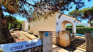A villa entrance with a stone gate, a pool, and a sign indicating the property name. - Villa with private pool,  at 150 m of the beach (Ciutadella de Menorca)