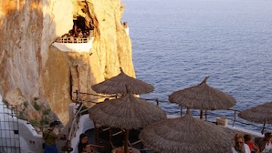 A seaside restaurant with outdoor seating and thatched umbrellas, overlooking the ocean. - Villa with private pool,  at 150 m of the beach (Ciutadella de Menorca)