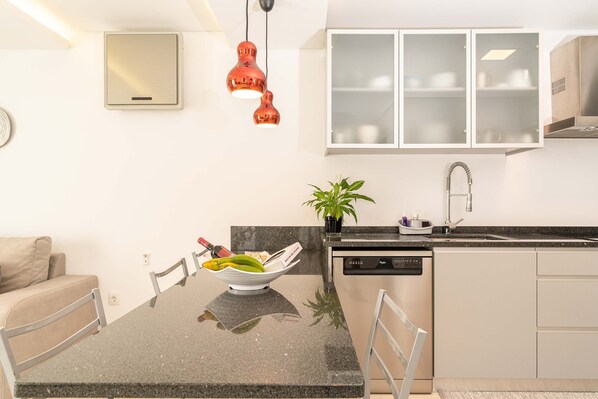 A modern kitchen with a granite countertop, a built-in dishwasher, and a two-bowl fruit bowl. - Casa Félix, Calheta: Villa with unique view! Private Pool! (Madeira)