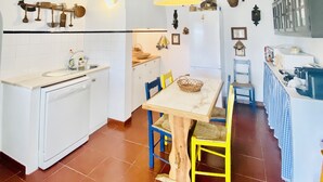 A compact kitchen with a central island, a built-in dishwasher, and a hanging light fixture. - Private farm with pool in the Alentejo (Vila Nova da Baronia)