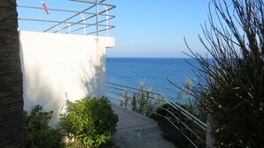 Ein Weg führt zu einem weißen Gebäude mit Blick auf das Meer.