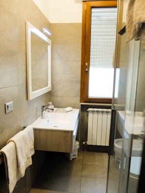 Een bad/douchecombinatie, een haardroger, een bidet, handdoeken