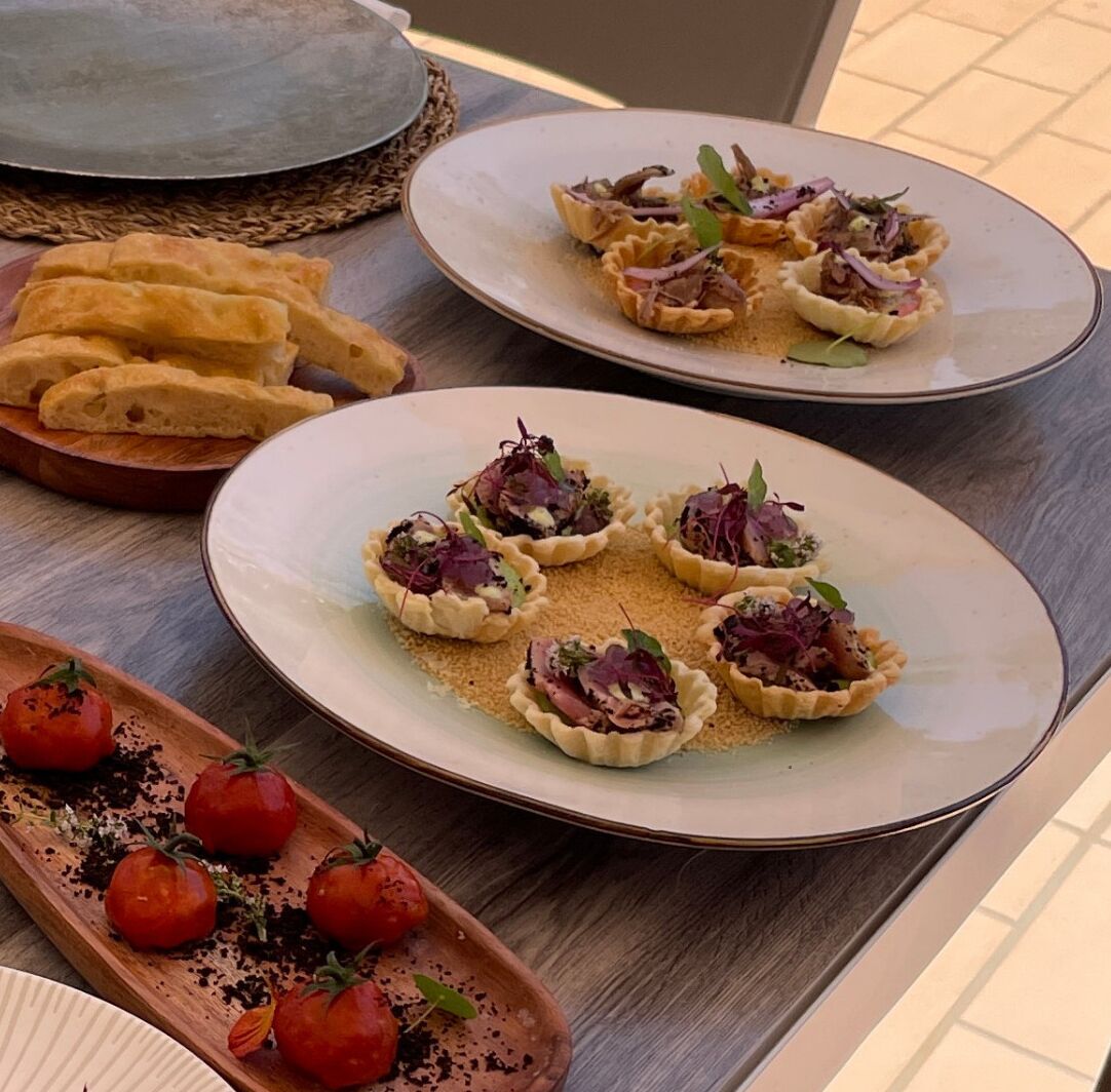 A table with food items including quiches, bread, and tomatoes.