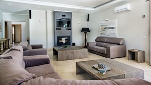 Una sala de estar moderna con un sofá modular, una mesa de centro y una chimenea.