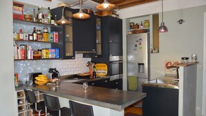 Une cuisine moderne dotée d’un îlot central, de tabourets de bar et de divers appareils de cuisine.