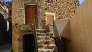 A stone staircase leading to a wooden door, flanked by a stone wall and a building with a tiled roof. - House of character in Feliceto Corsica, classified 4 stars (Feliceto)