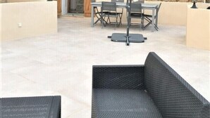 A stone building with a patio area featuring outdoor furniture and a table with chairs. - House of character in Feliceto Corsica, classified 4 stars (Feliceto)