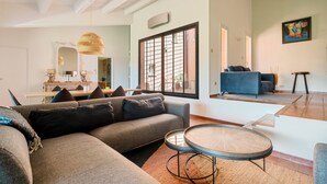 A modern living room with a sectional sofa, a round coffee table, and a large window with a view. - Luxury Villa 5 * - Cassis (Cassis)