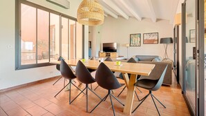 A modern dining area with a large table, four chairs, and a woven pendant light. - Luxury Villa 5 * - Cassis (Cassis)