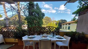 An outdoor dining area with a table set for four, surrounded by chairs.