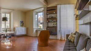 Un salon moderne avec un escalier, un coin repas et une vue sur un bâtiment historique.