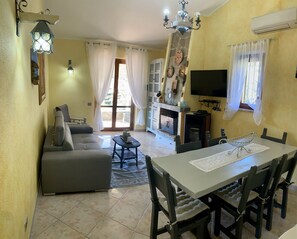 Télévision, cheminée, lecteur de DVD, livres