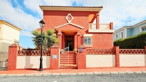 Un bâtiment rouge doté d’un balcon, d’un escalier et d’une porte.