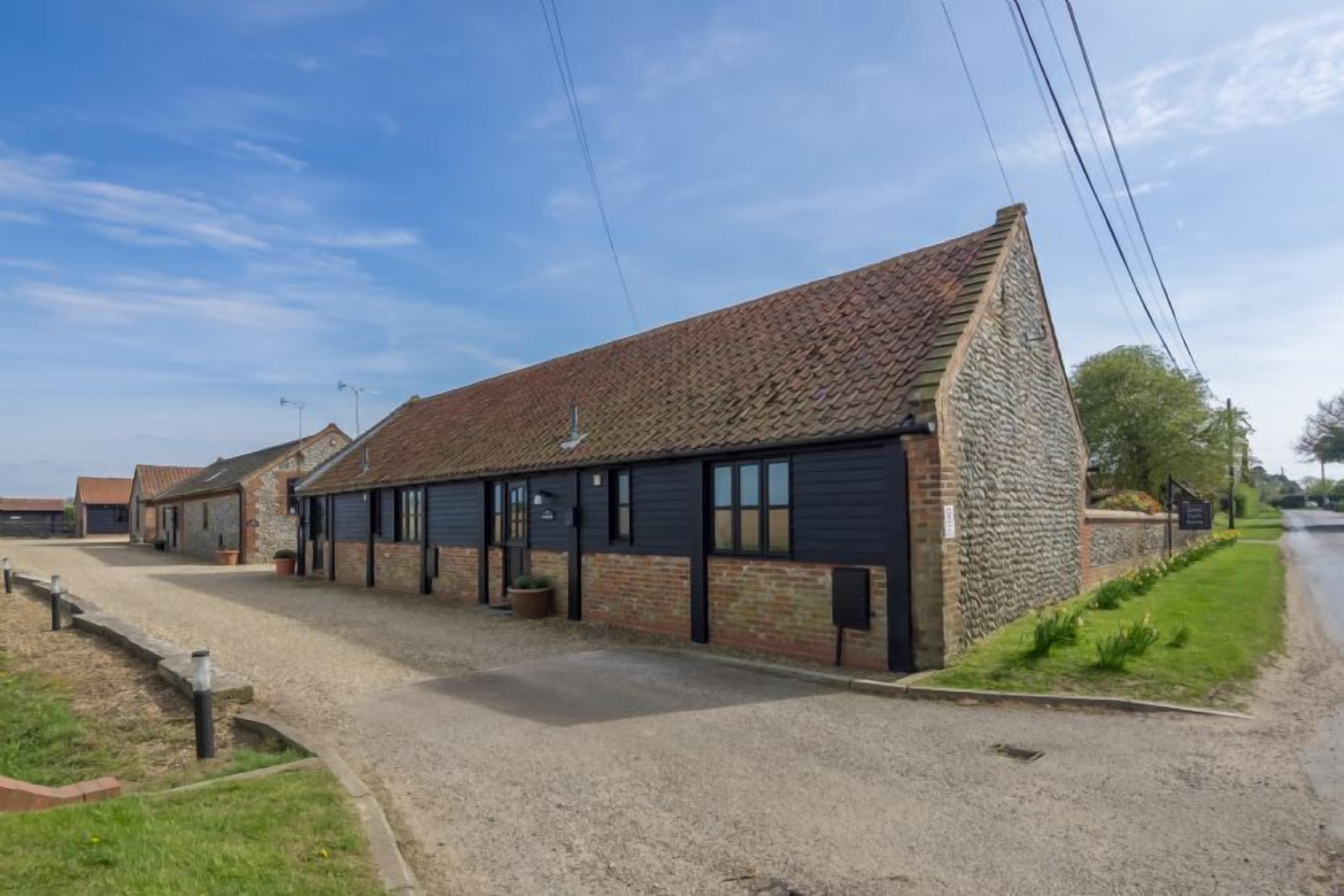 A long, narrow building with a sloped roof, likely a barn or storage facility.