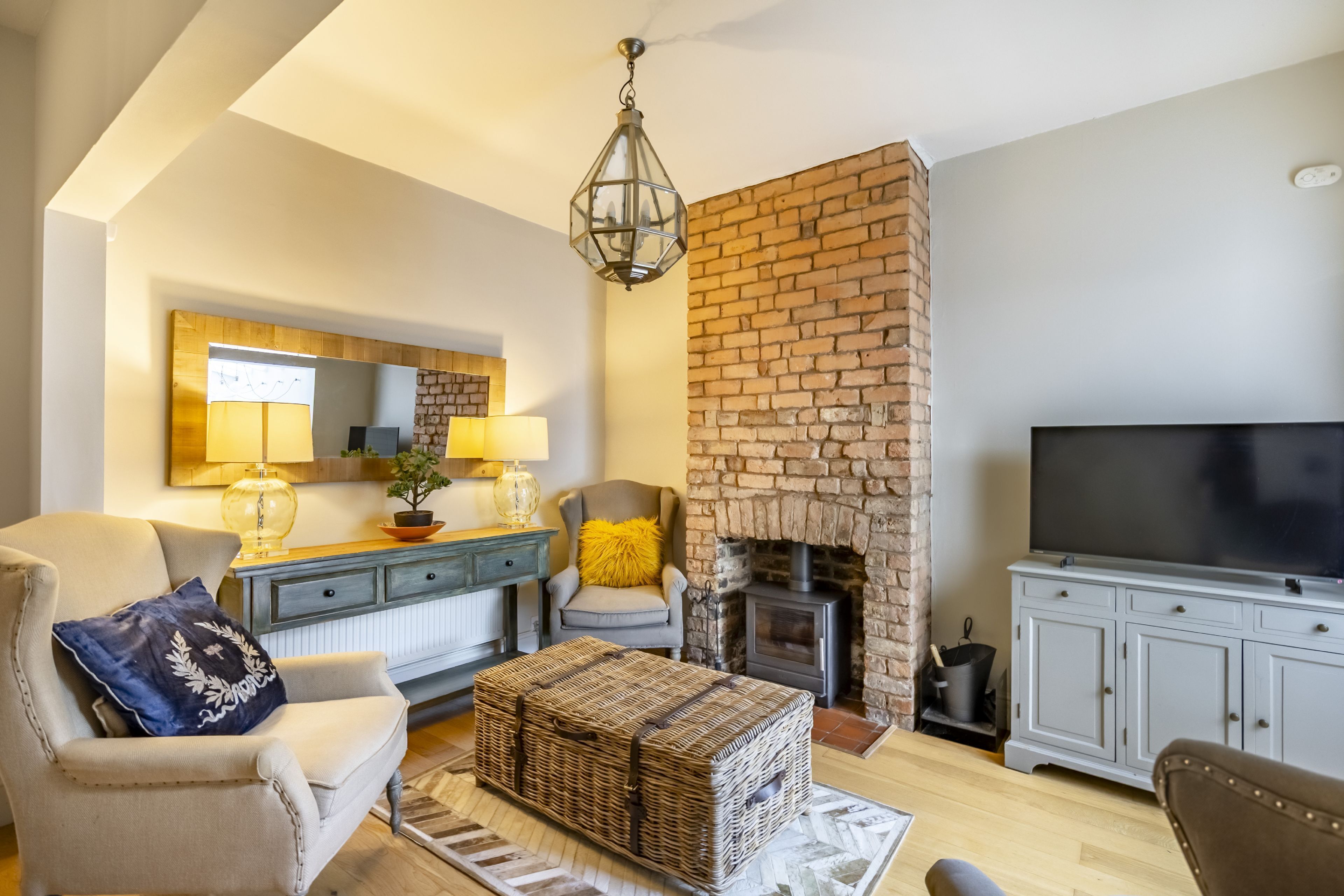 Ein Wohnzimmer mit Kamin, Fernseher, Sofa und Couchtisch.