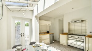 A modern kitchen with a dining area, a built-in oven, and a dishwasher.