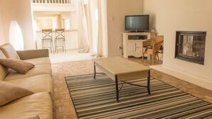 Un salon comprenant un canapé, une table basse, un téléviseur et une cheminée.
