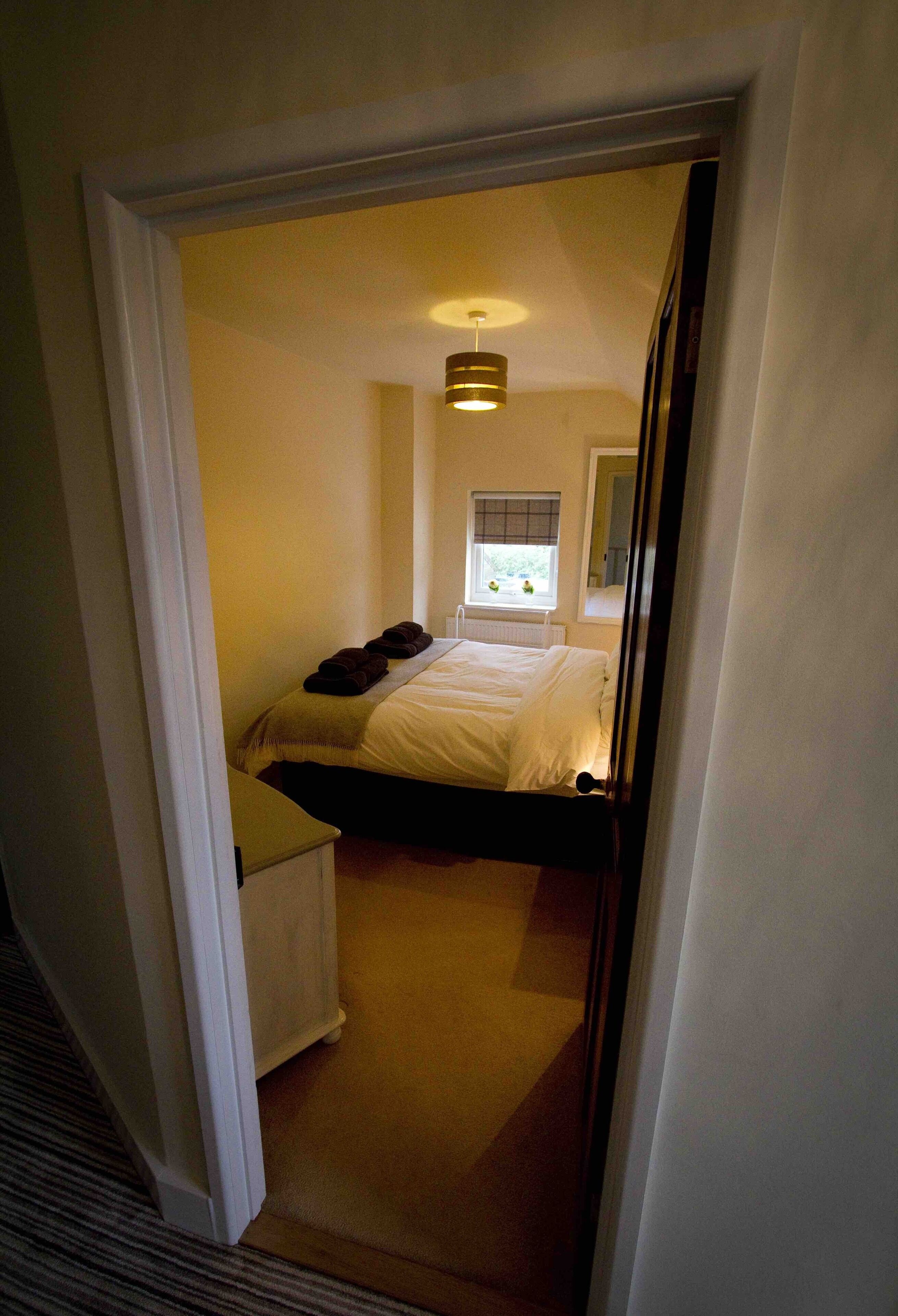 Une chambre à coucher avec un lit, une fenêtre et un radiateur.
