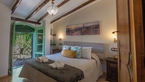 Une chambre à coucher avec un lit, un lustre, un tableau et une porte.