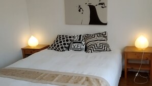 A bedroom with a bed, two bedside tables with lamps, a wall-mounted painting, and a patterned throw blanket. - House / Villa - Saint Maur des Fossés - 30mn from Paris center (Saint-Maur-des-Fosses)