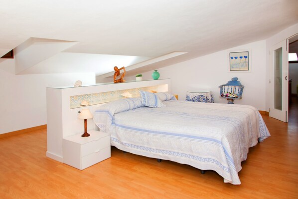 A bedroom with a bed, nightstand, and a decorative shelf with items. - Elegant Family Villa with Private Pool, Jacuzzi, Spacious Garden & Games Area (Crestatx -Sa Pobla)