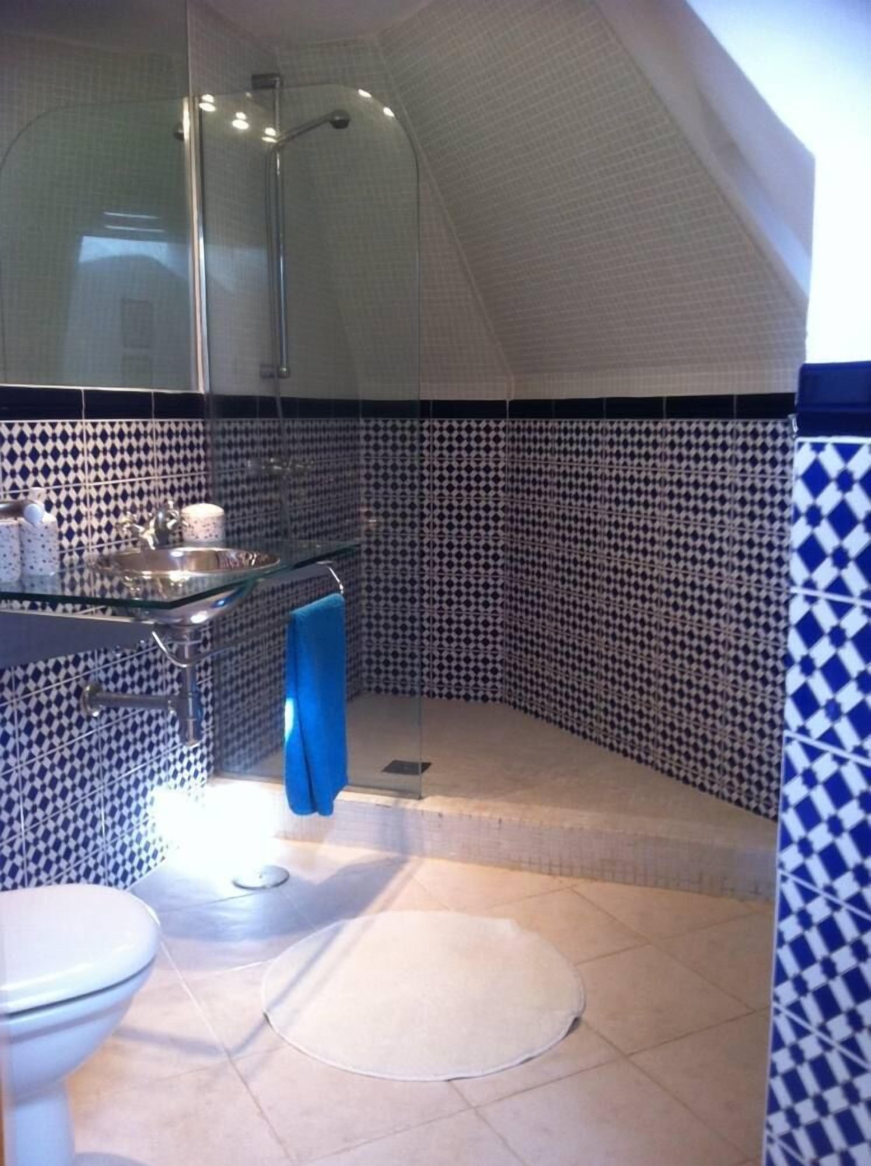 Une salle de bain avec douche, toilettes et lavabo.