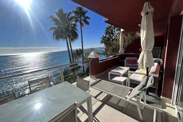 Balcony with seating area and table.