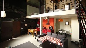Moderni loft-tyylinen asunto, jossa on ruokailutila, keittiö ja parvitason makuuhuone.